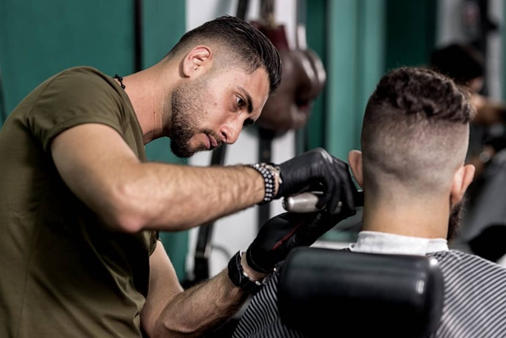 A professional barber cutting a customer's hair