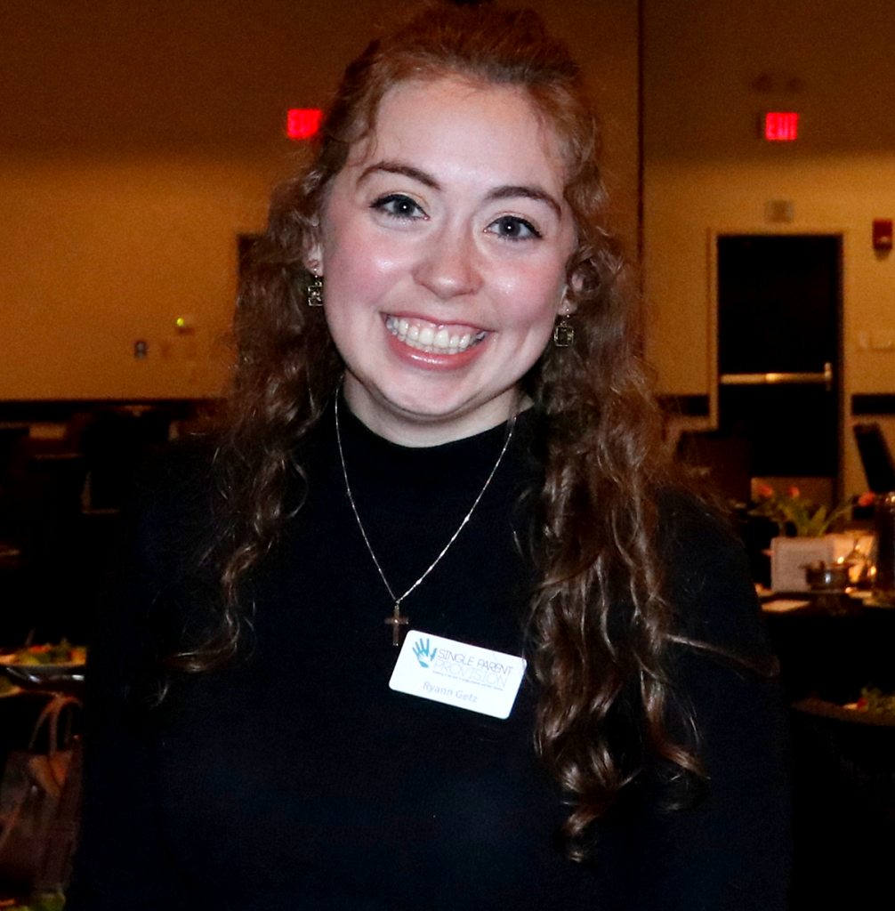 Event photography. 1 woman in a black shirt smiling at the camera.